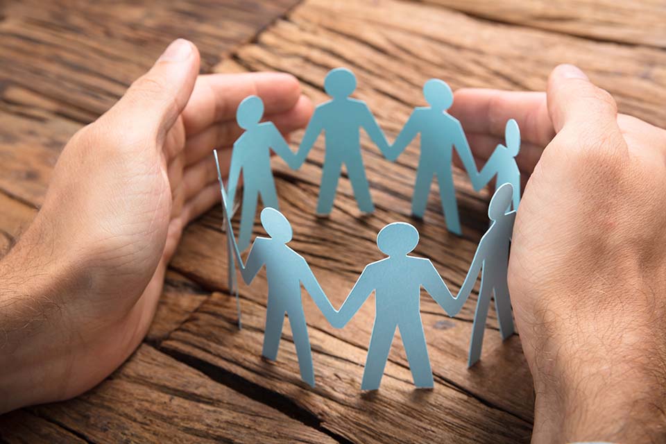 paper people cut outs surrounded by hands