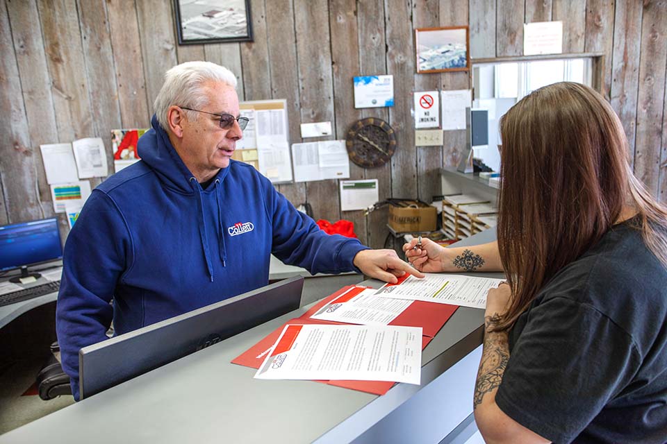 collett employee helping customer fill out papers